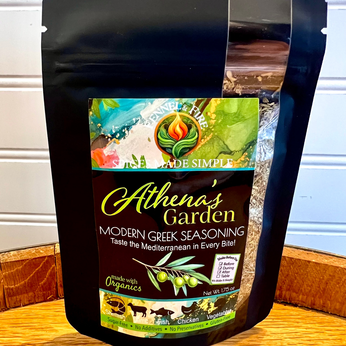 Athena's Garden Modern Greek Seasoning package on a wooden surface with a white wall background