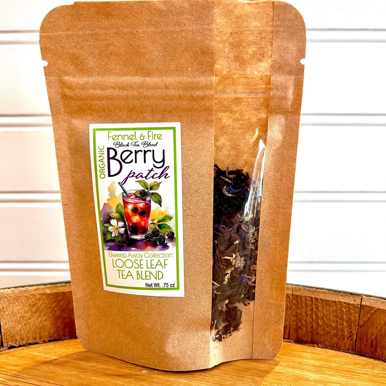 Brown paper bag of berry patch loose leaf tea blend on a wooden surface with a white background