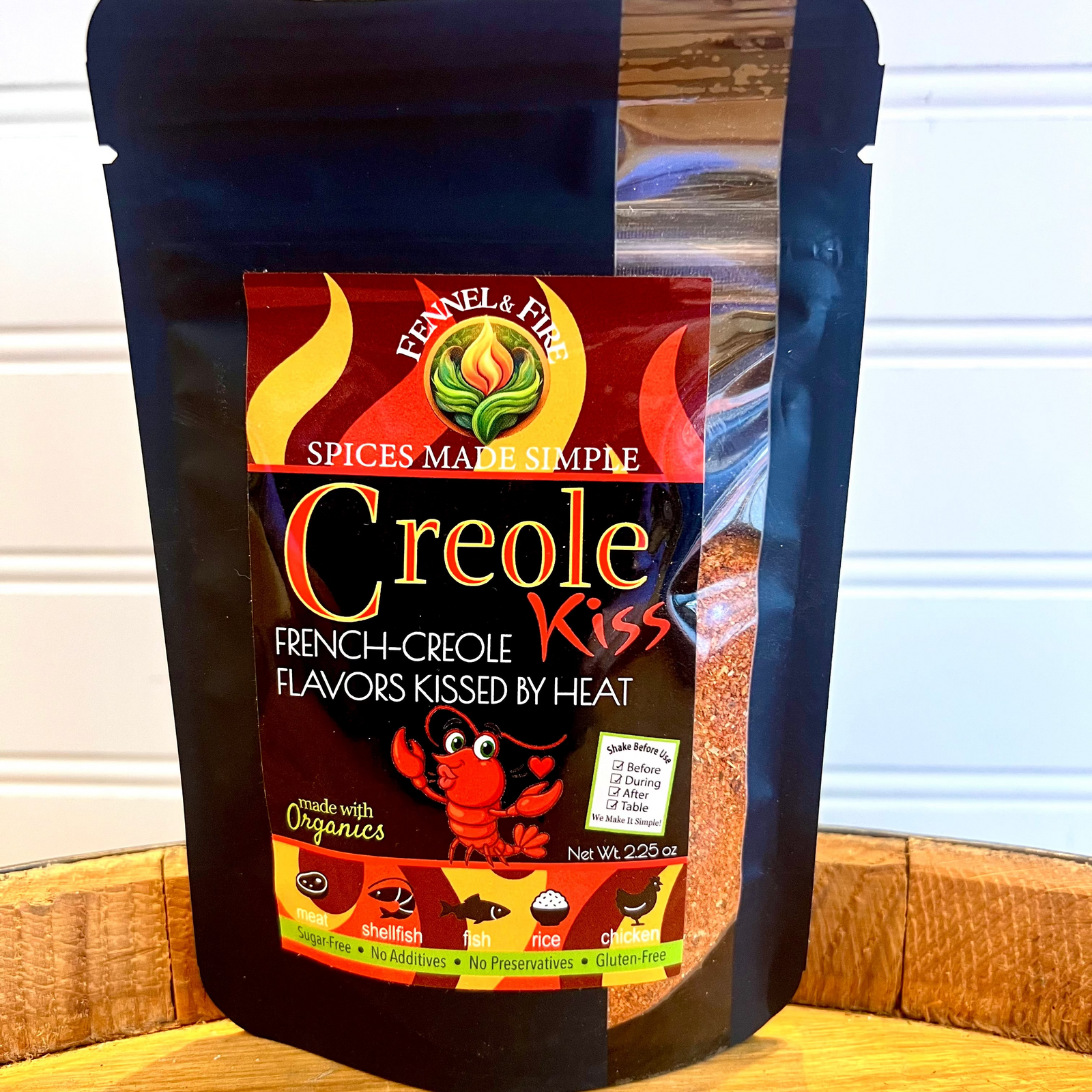 Bag of Creole Kiss seasoning on a wooden surface with a white background