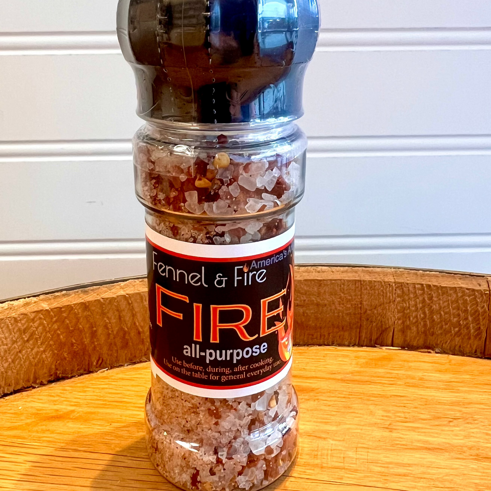 Fennel & Fire all-purpose Fire Salt seasoning bottle on a wooden surface with a white background