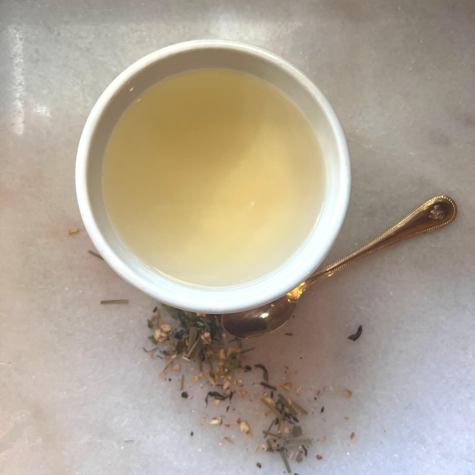 Total EclipseTea Blend in white cup on white marble with gold spoon