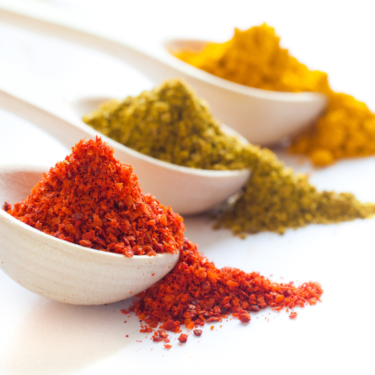 Spices in white spoons on a white background