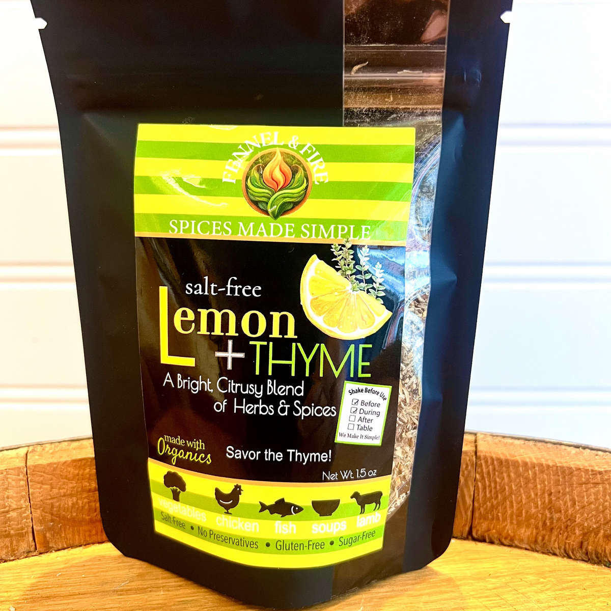 Spice blend package labeled 'Lemon + Thyme' on a wooden surface.