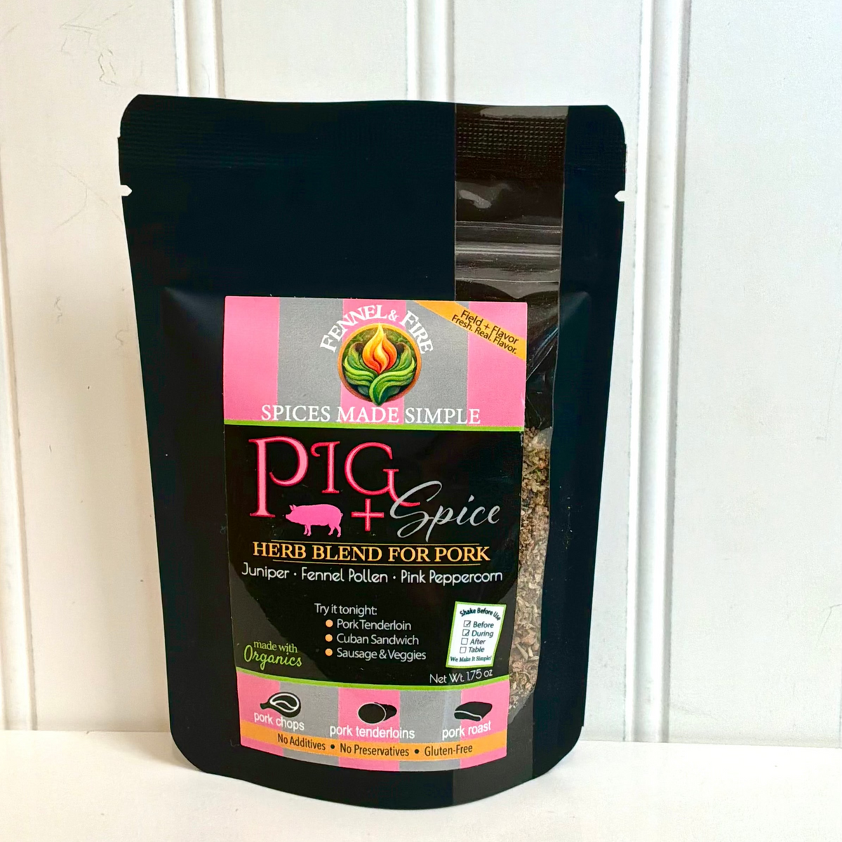 A black stand-up pouch of Pig + Spice Herb Blend for Pork, featuring a pink and green label, set against a white paneled background.
