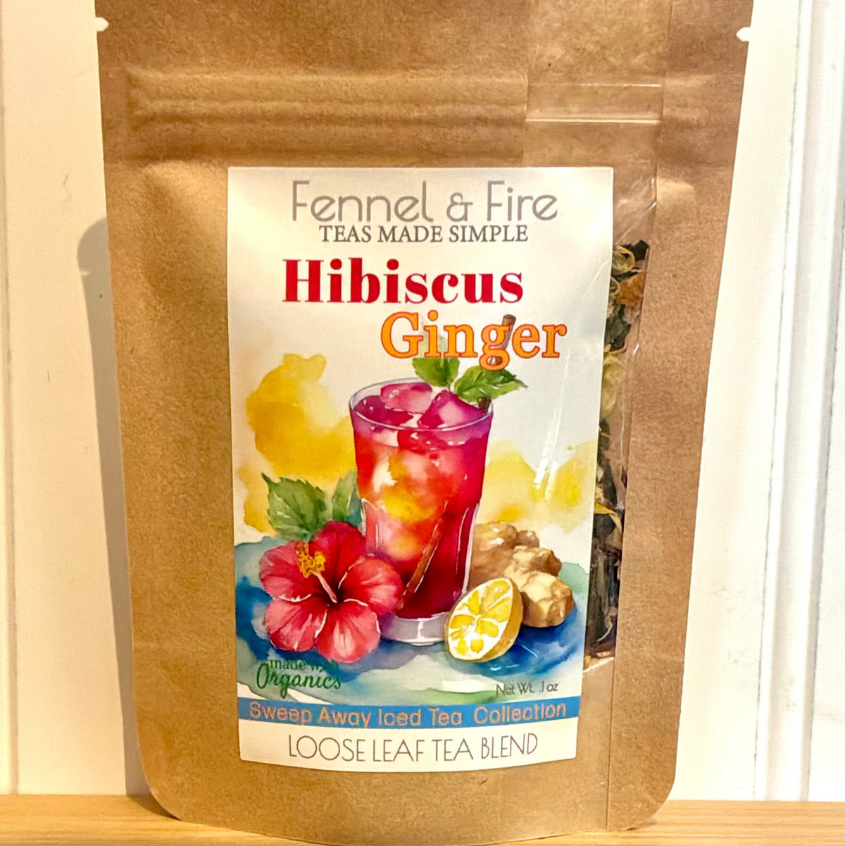 Fennel & Fire Hibiscus Ginger tea package on a wooden surface